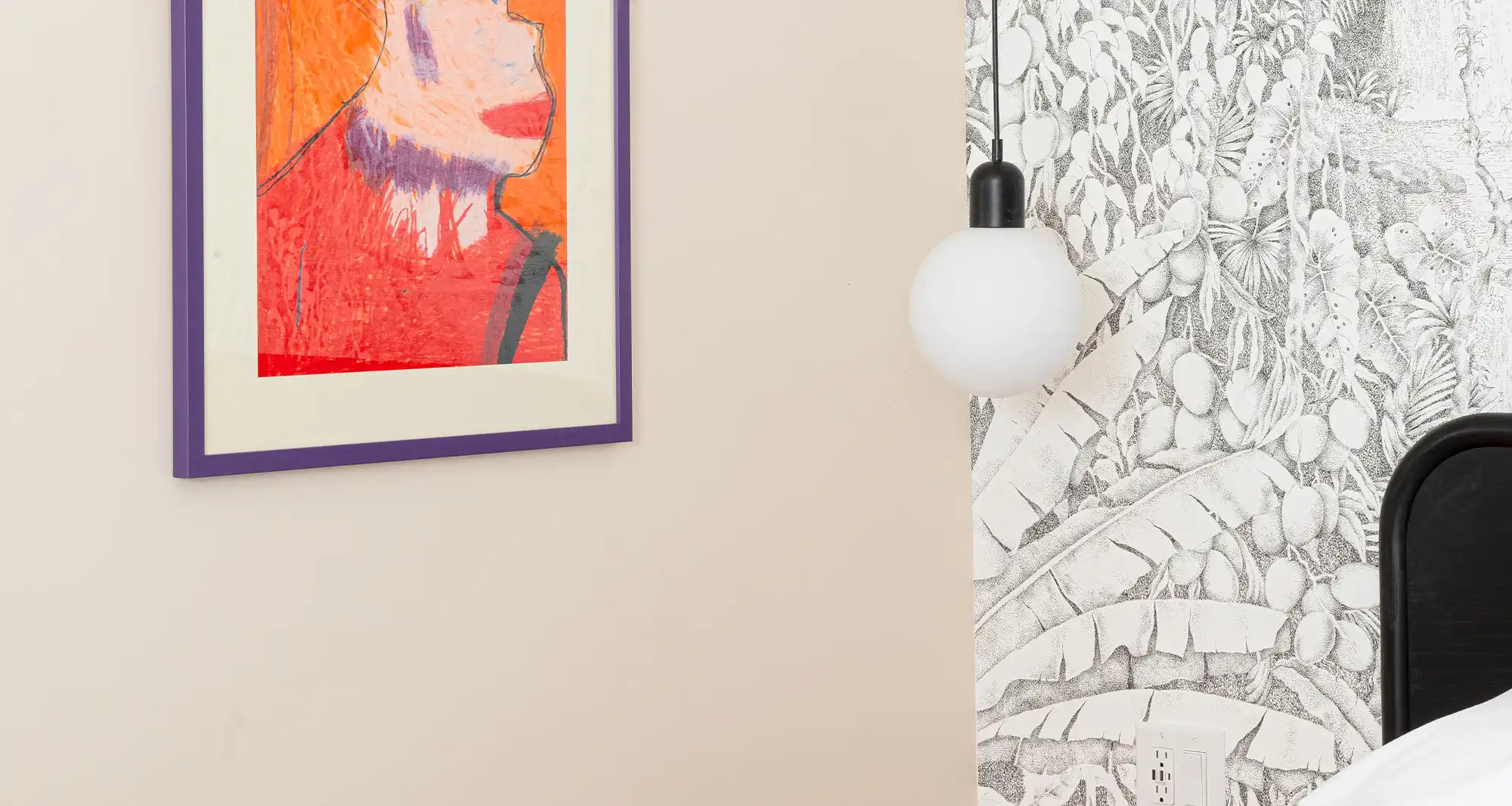 Corner of beige a room with a colorful painting hanging on the wall and a floating lamp