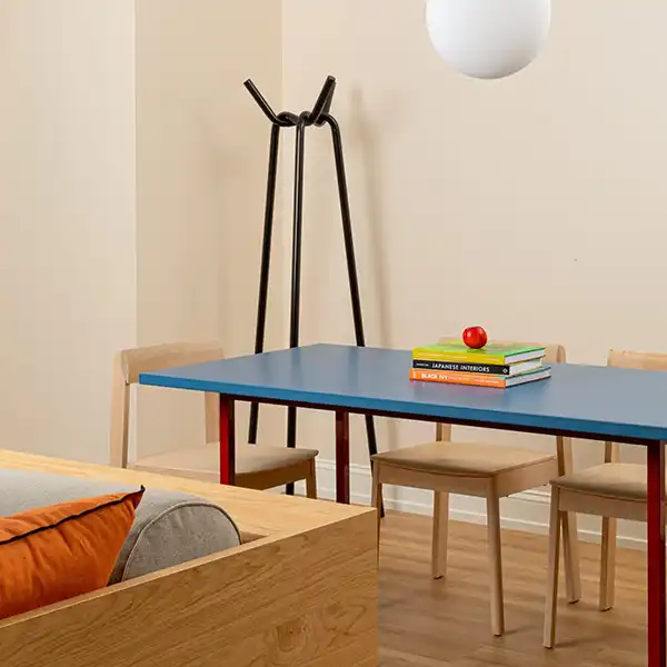 blue dining table with books on it, an apple and a floating lamp