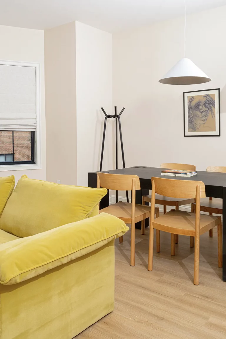 Black wood table with 4 wood chairs around, books on top and a hanging lap