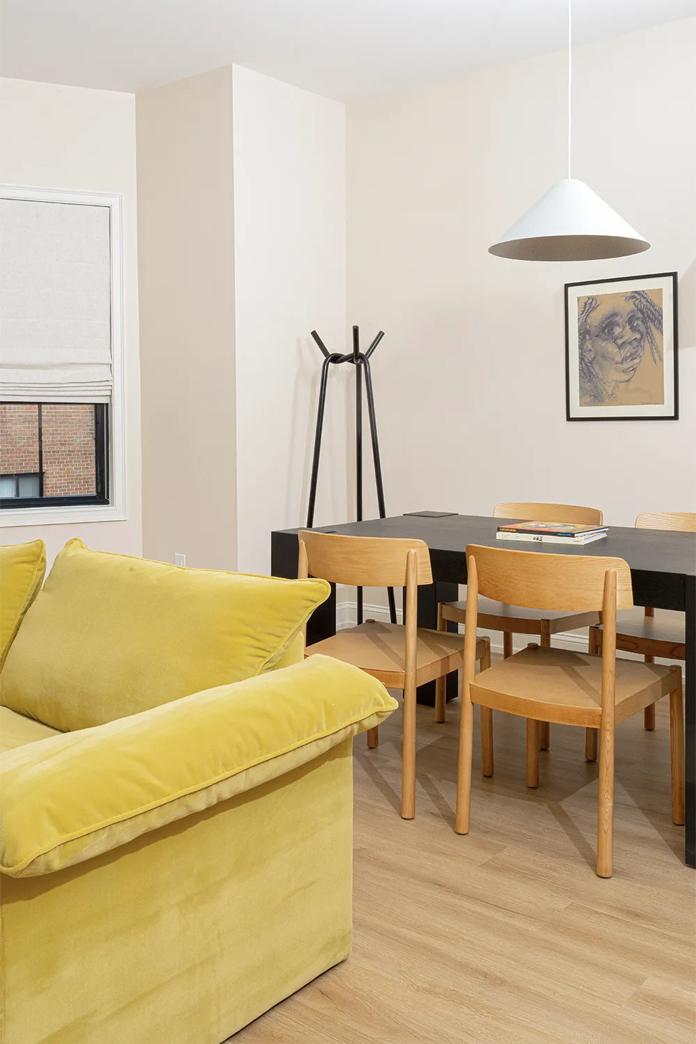 Black wood table with 4 wood chairs around, books on top and a hanging lap
