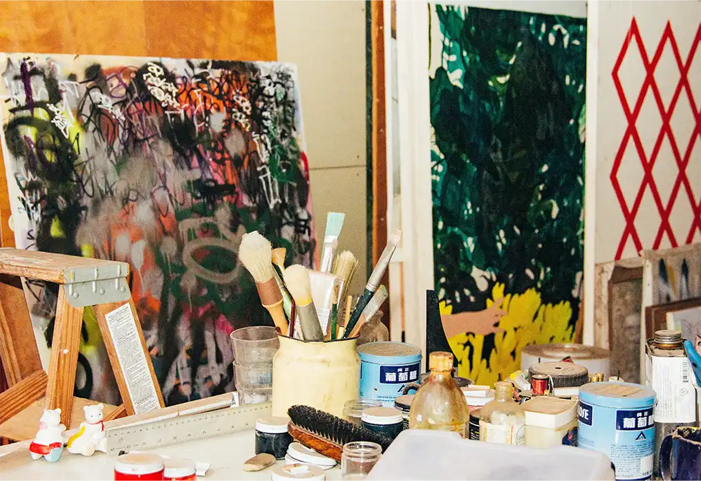 photo of a canvas next to paints and brushes