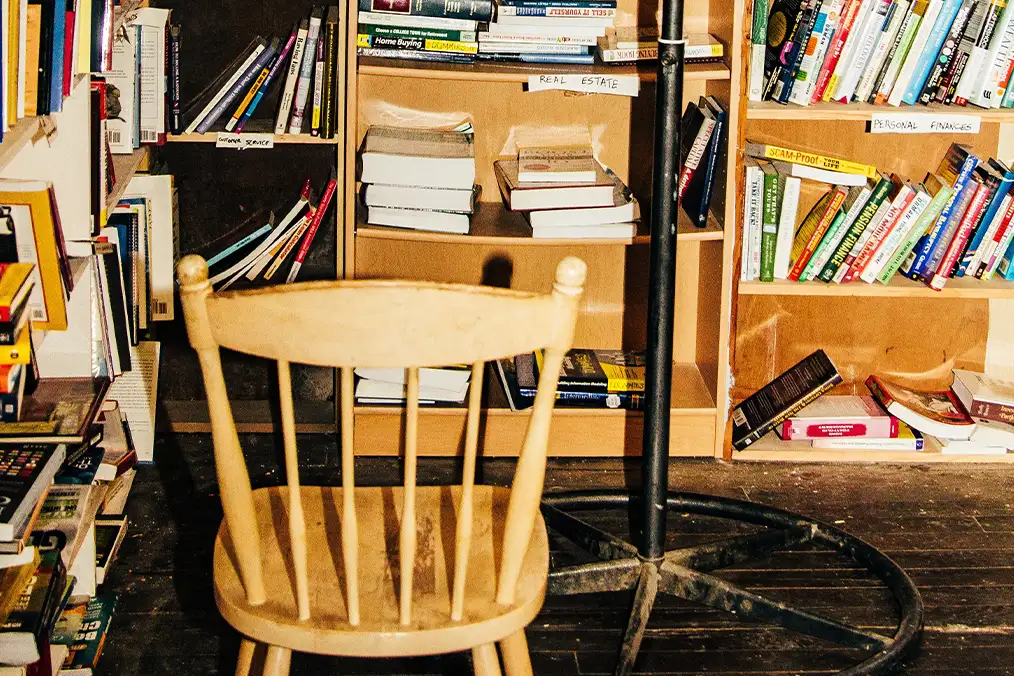 a wooden chair in the middle of a library