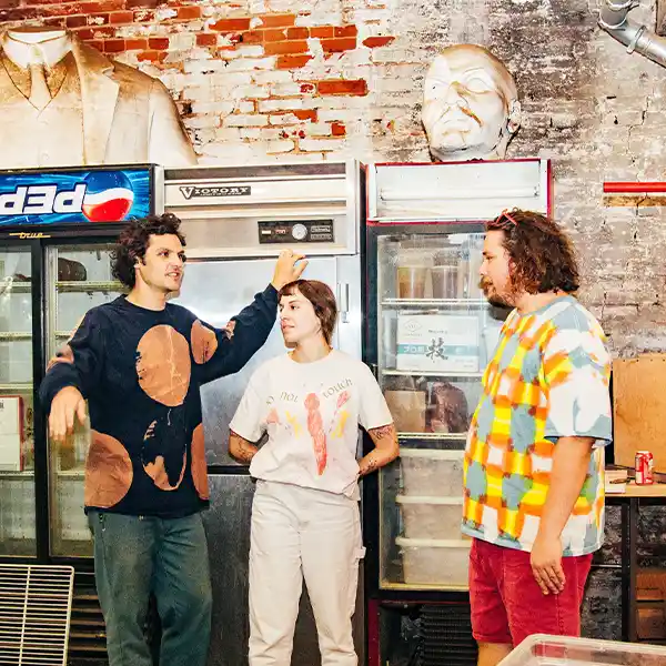 A woman between two men talking in a rustic place