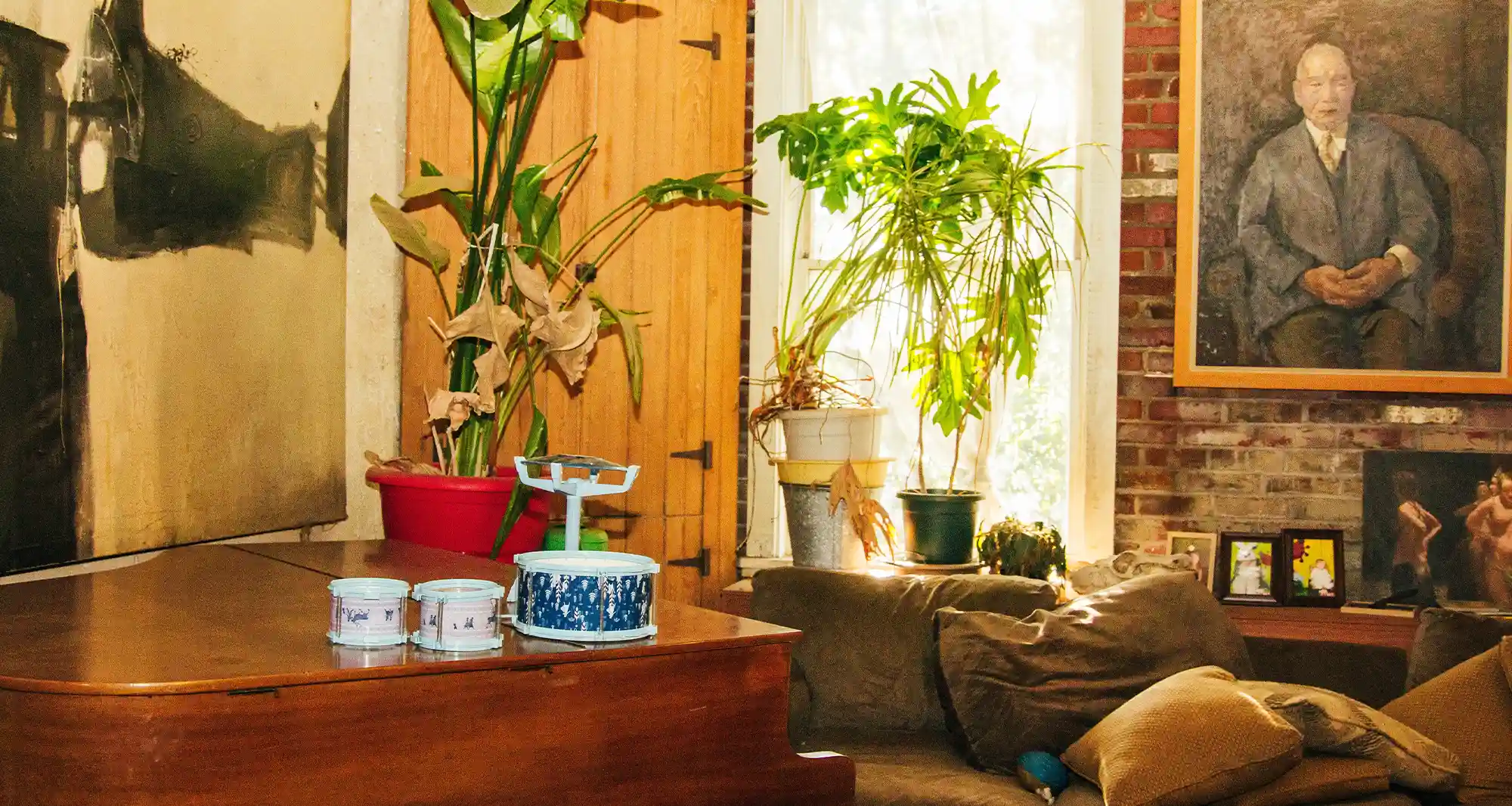room full of plants, art and a piano