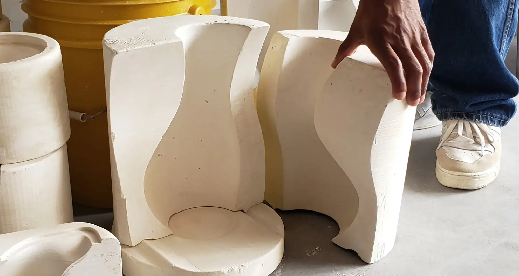 Close-up of a man's hand holding a concrete piece of art