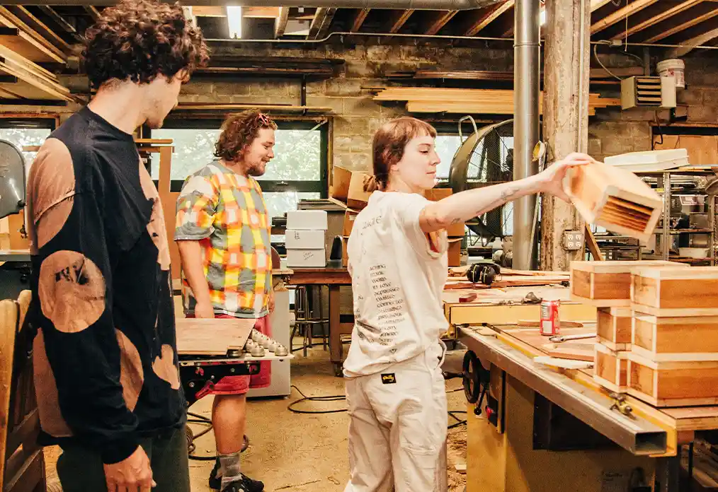 Three people working in a carpentry shop