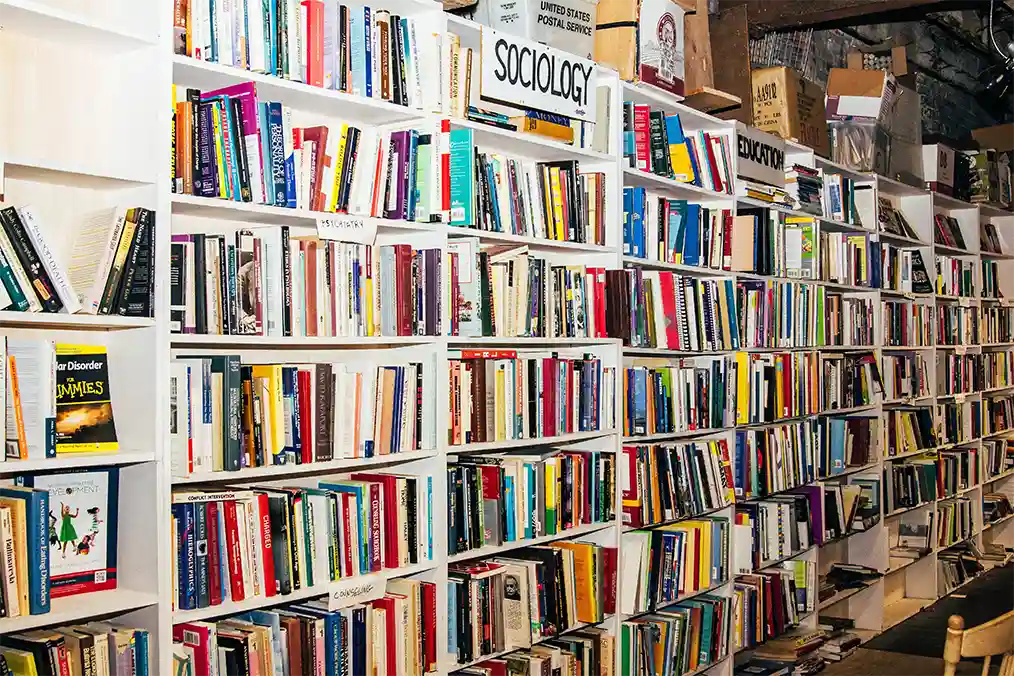White-shelf bookcase with a sign that says sociology