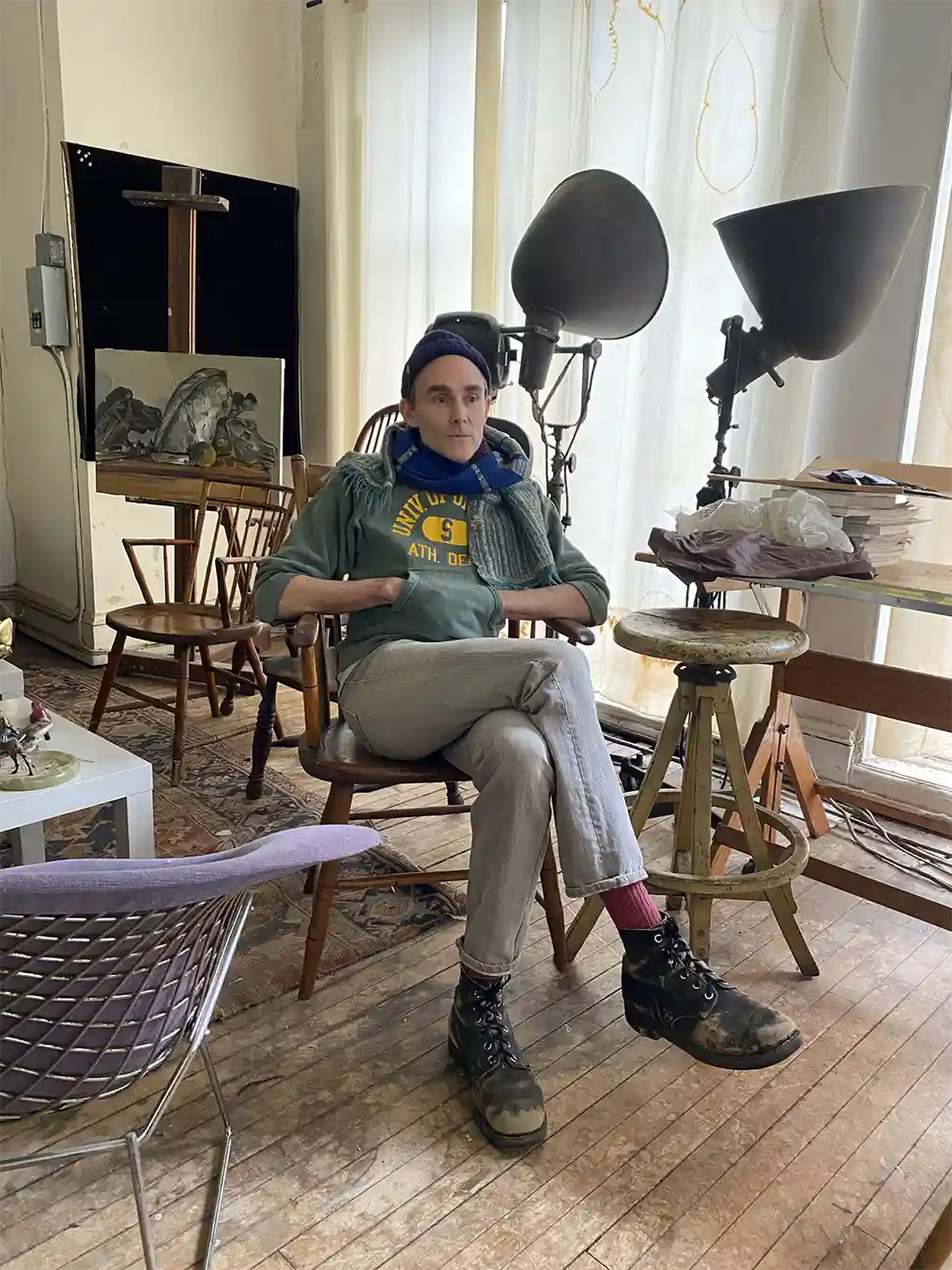 man sitting in the middle of an art studio