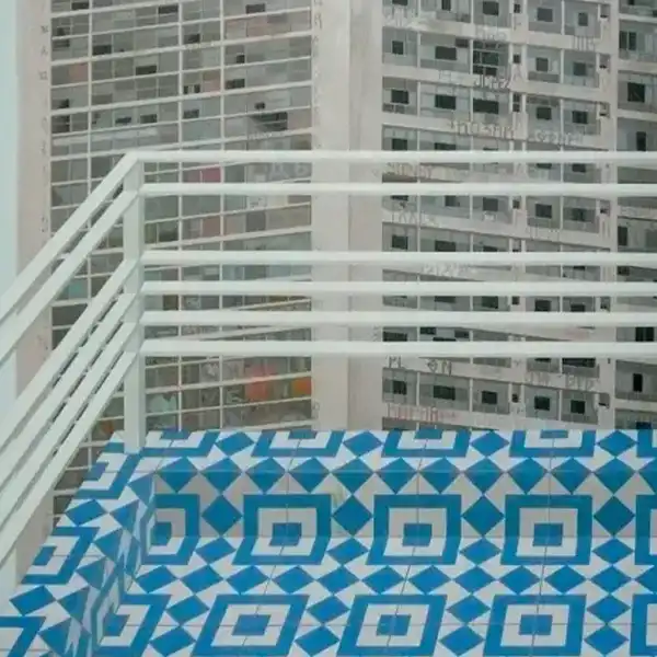 Photograph of some blue tiles with a white fence and a building behind them