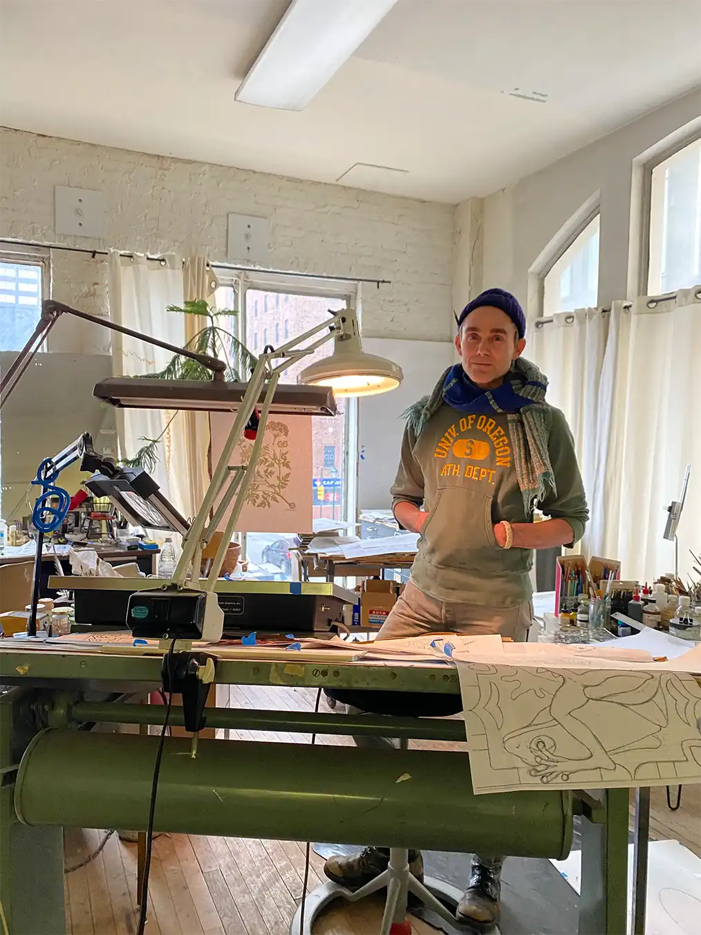 man in a wool hat posing in a wax printing studio