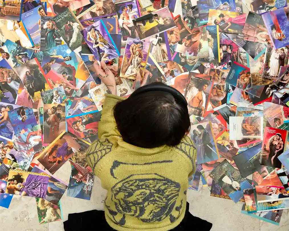 woman lying face down on thousands of photos scattered on the floor