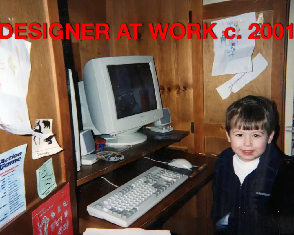 image of a small boy in an office in front of a computer from the 2000s