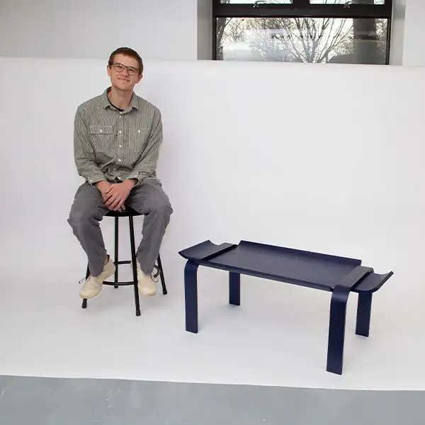 man sitting on a white background next to a table