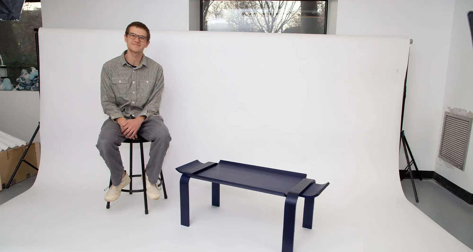 man sitting on a white background next to a table