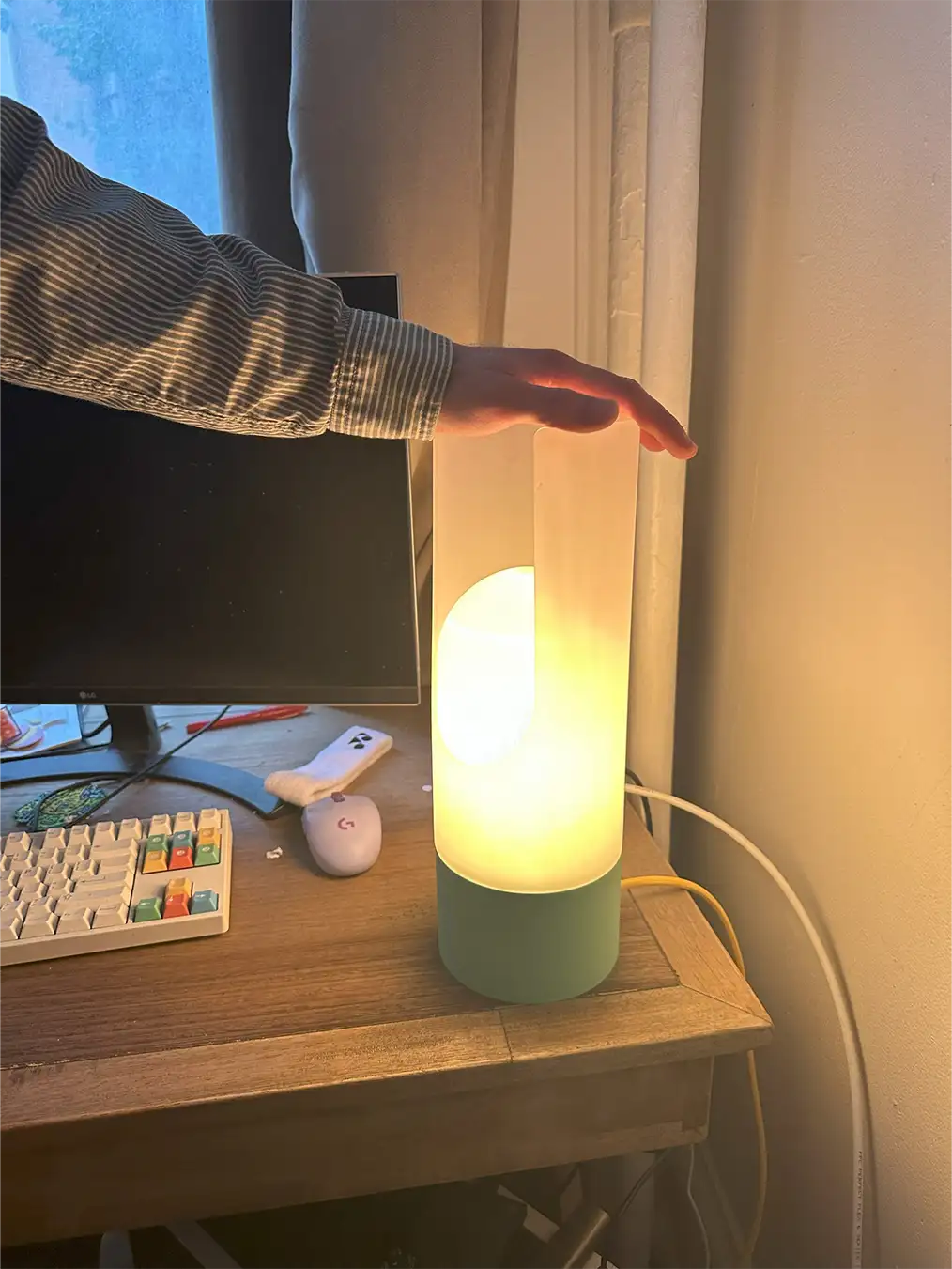 a lamp on a desk with a hand on it