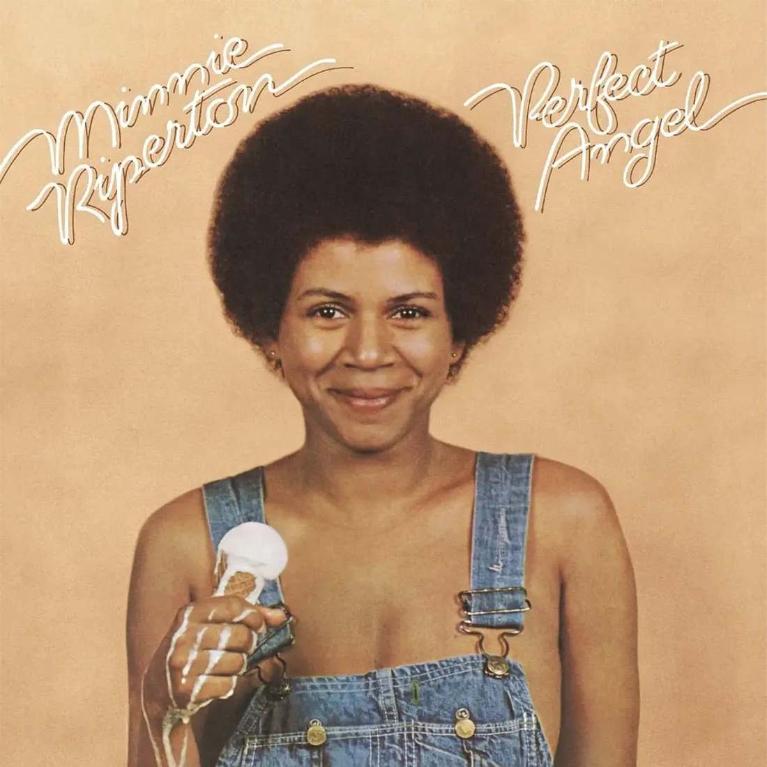 Afro woman wearing a jean overall holding a melted vanilla ice cream cone