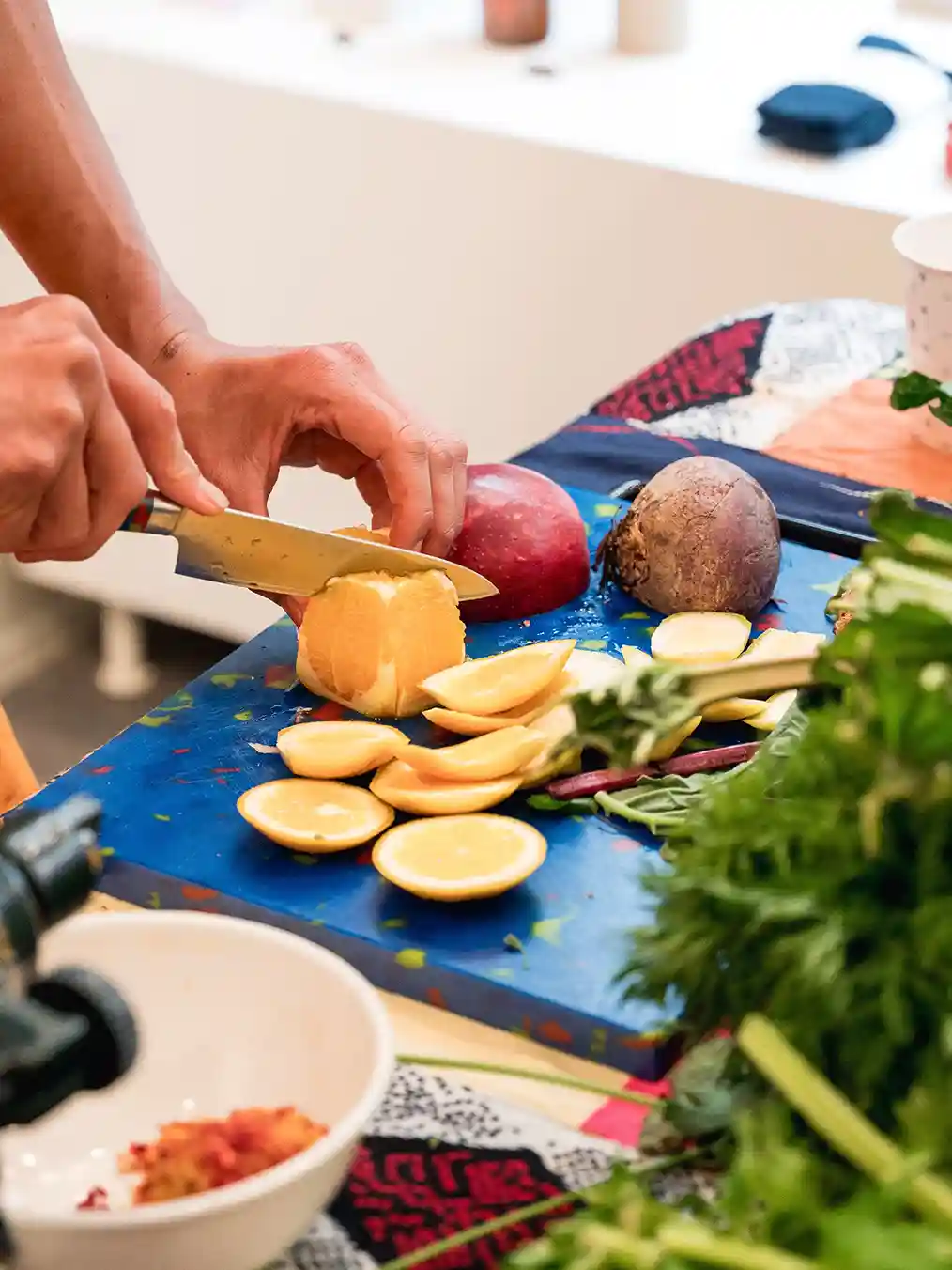 a person cutting vegetables on a blue board