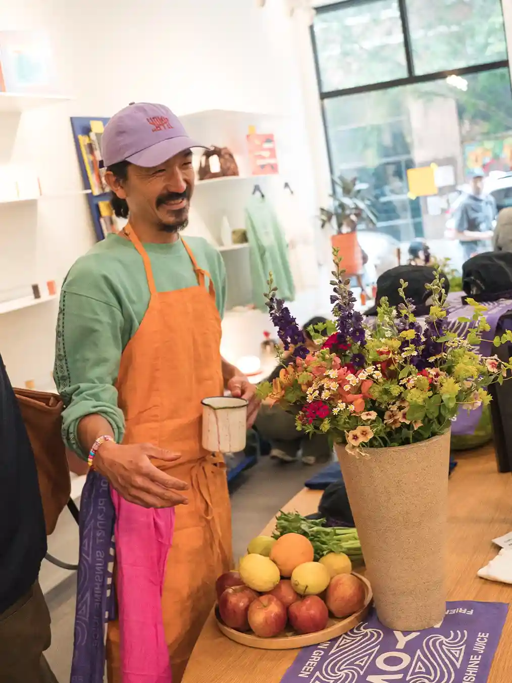 man in a purple cap serving in a flower shop