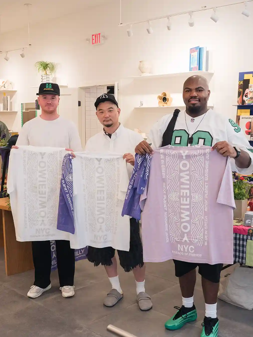 three men holding white and lilac towels