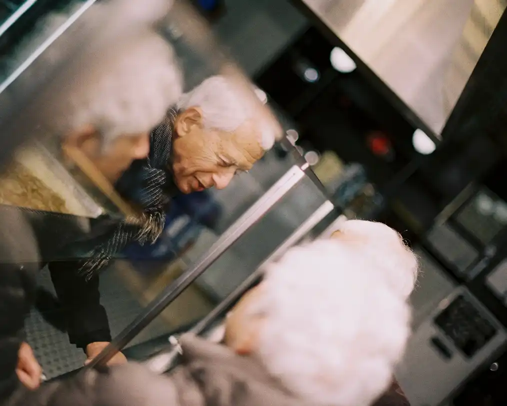 two elderly people with their backs to each other
