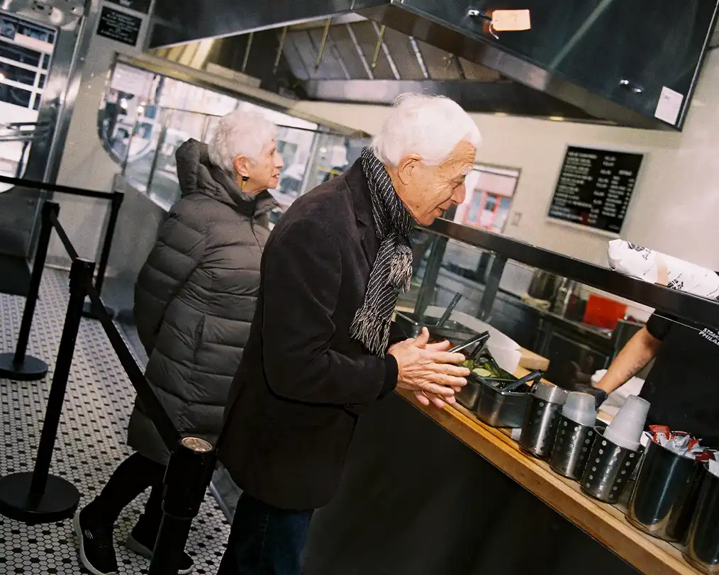 two senior citizens ordering a coffee