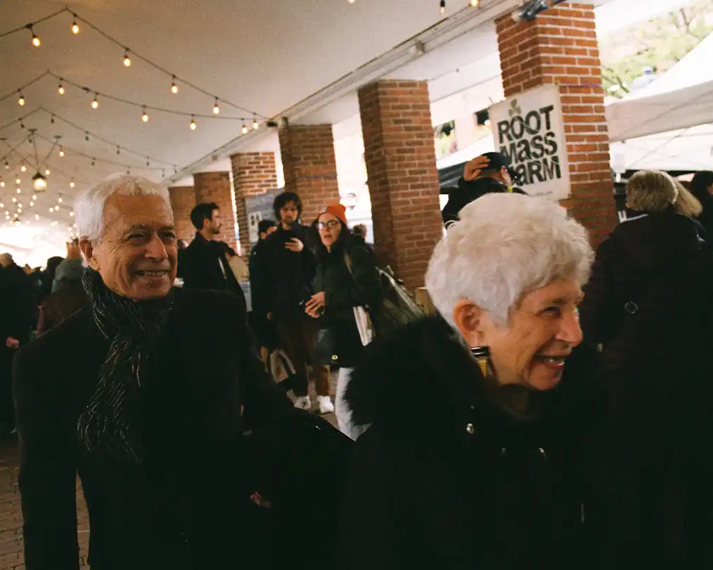two old men walking in the middle of the crowd