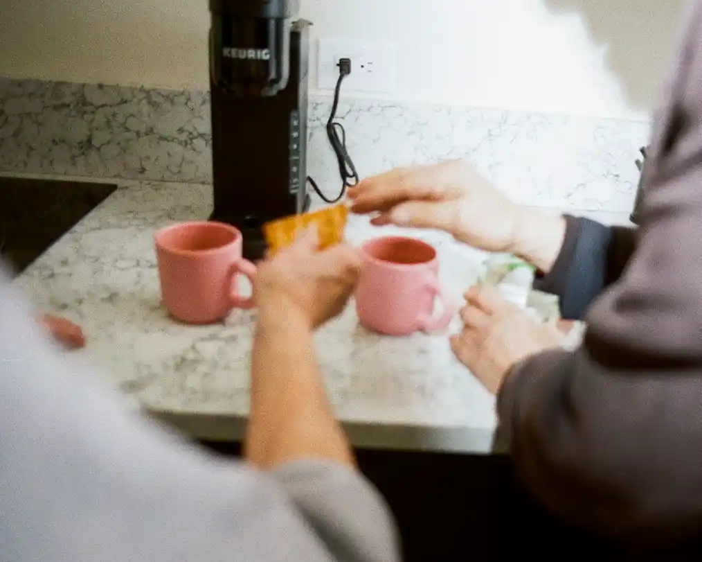close-up of two people serving tea