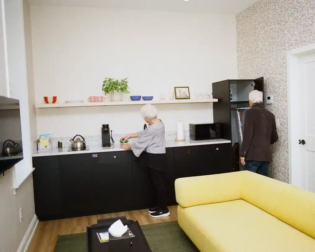 yellow living room next to black kitchen