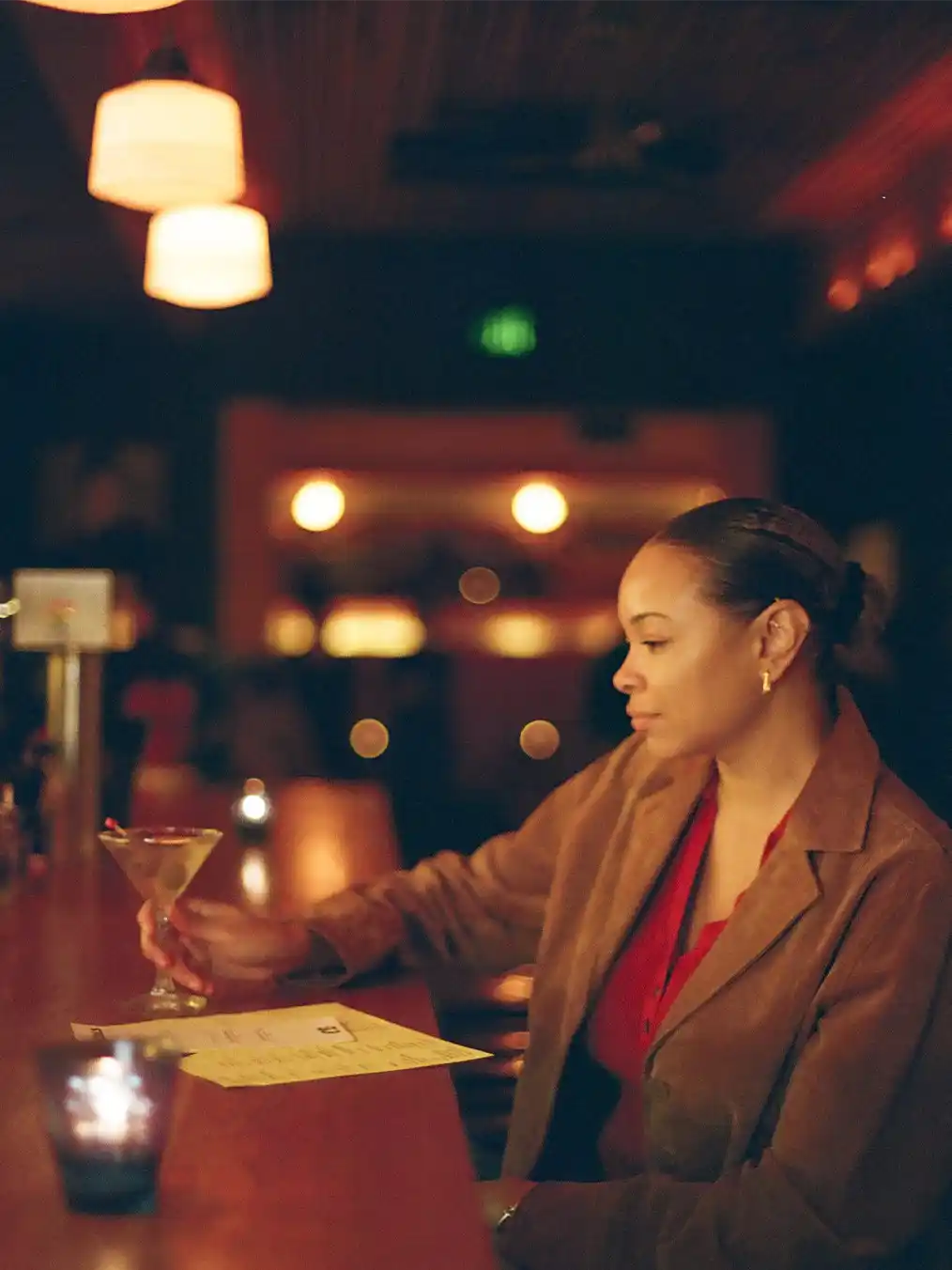 young woman drinking a drink at the bar of a bar