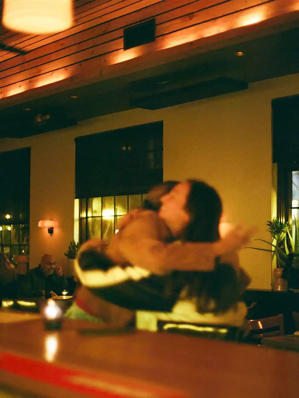 two friends hugging in a bar