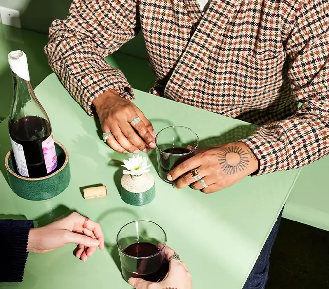 two people sitting at a green table having drinks