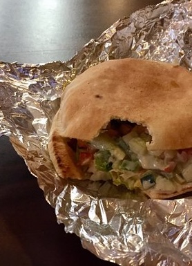 Alyan’s pita sandwich wrapped in foil with fresh vegetables inside.